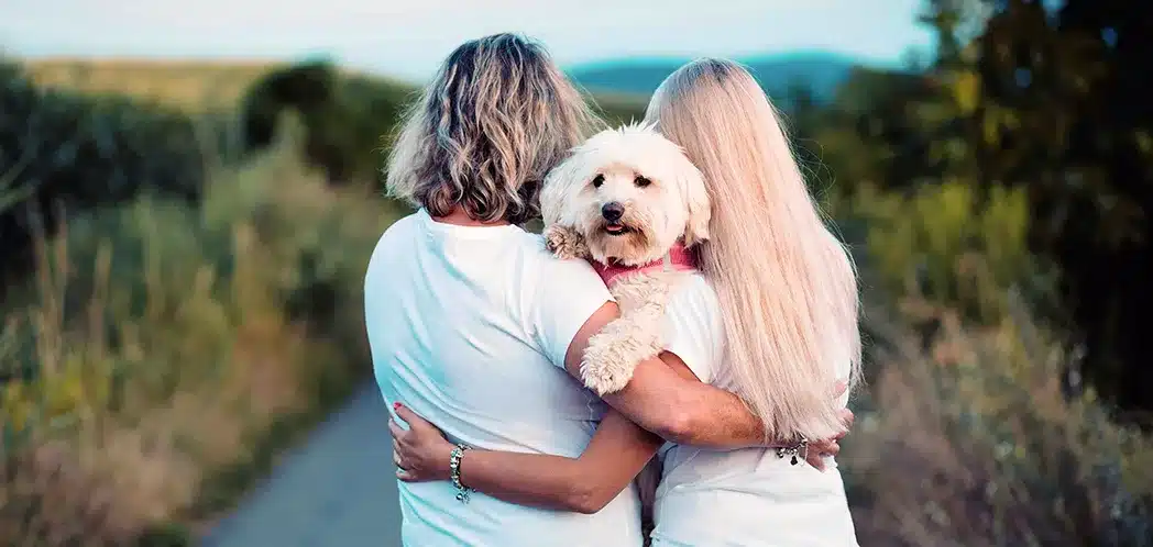 To personer sammen med en liten hund.